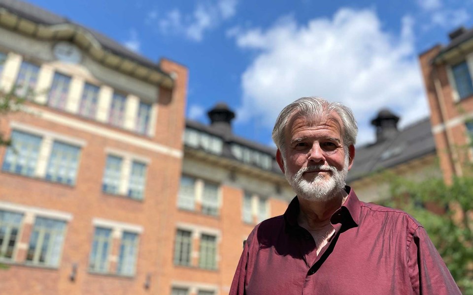Arkitekturhistoriker Martin Rörby framför Matteusskolans huvudlänga.
